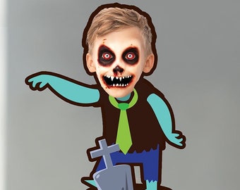 May include: A cupcake topped with white frosting and a red raspberry. A cartoon zombie with a green tie and a tombstone is on a stick in the cupcake.