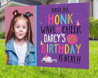 Puede incluir: Un letrero de jardín de cumpleaños con una foto de una niña y el texto "Drive by, Honk, Wave and Cheer, Darcy's 6th Birthday is Here!!" El letrero es morado, rosa, amarillo y azul, con un dibujo de un coche.