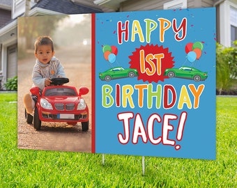 Puede incluir: Un cartel de cumpleaños azul y rojo con el texto "Happy 1st Birthday Jace!" en letras de colores. Una foto de un niño en un coche de juguete rojo está en el lado izquierdo del cartel.