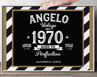 May include: A framed black and gold sign with the name "Angelo" and the year "1970" in white text. The sign has a gold glitter border and a black and white striped border. The text includes "Vintage", "Limited Edition", "Aged to Perfection", "One of a Kind", and "Authentic Parts".