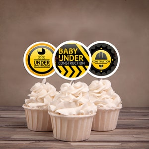 Puede incluir: Tres adornos para cupcakes amarillos y negros con el texto "Baby Under Construction" y un gr&aacute;fico de un trabajador de la construcci&oacute;n.