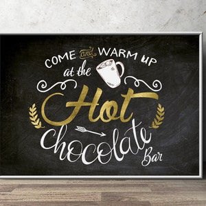 May include: Black chalkboard sign with white text that reads "Come and warm up at the Hot Chocolate Bar". The sign has a gold glitter finish and a white mug with marshmallows on top.