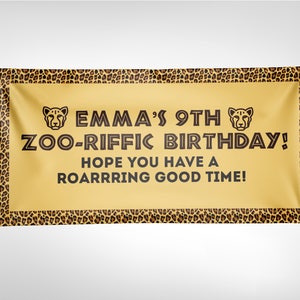 Puede incluir: Una pancarta amarilla con un borde de estampado de leopardo. La pancarta dice "Emma's 9th Zoo-riffic Birthday! Hope you have a roarrrring good time!" con iconos de cabeza de guepardo a cada lado del texto.