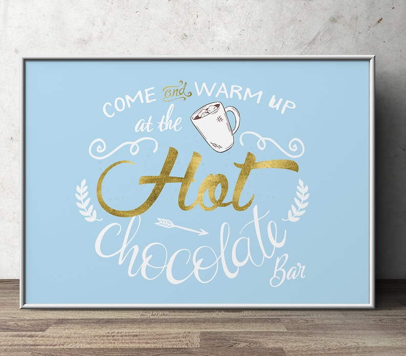 May include: A blue and white sign with gold lettering that says "Come and warm up at the Hot Chocolate Bar". The sign features a drawing of a mug of hot chocolate with marshmallows.