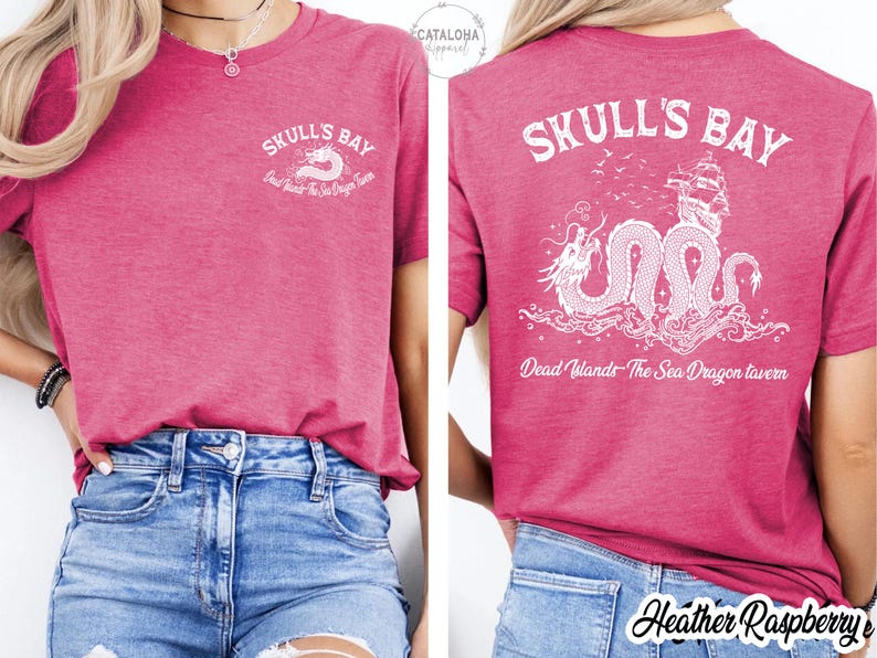 May include: Heather raspberry-colored t-shirt with white graphic text and a sea dragon design. The front of the shirt says "Skull's Bay" with a sea dragon graphic. The back of the shirt has the same text and a larger sea dragon graphic.