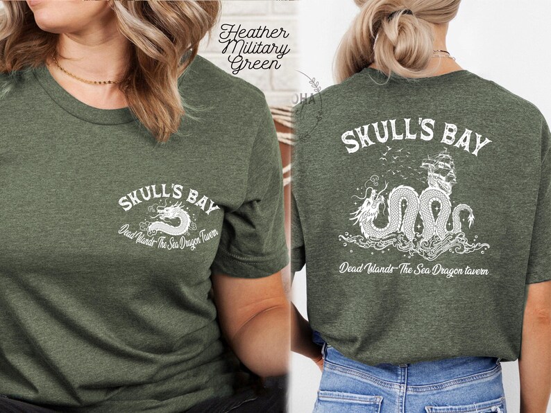 May include: Heather military green t-shirt with the text "Skull's Bay" and a white dragon graphic on the front. The back of the shirt features a larger graphic of a sea dragon, ship, and the text "Skull's Bay" and "Dead Winds - The Sea Dragon Tavern."