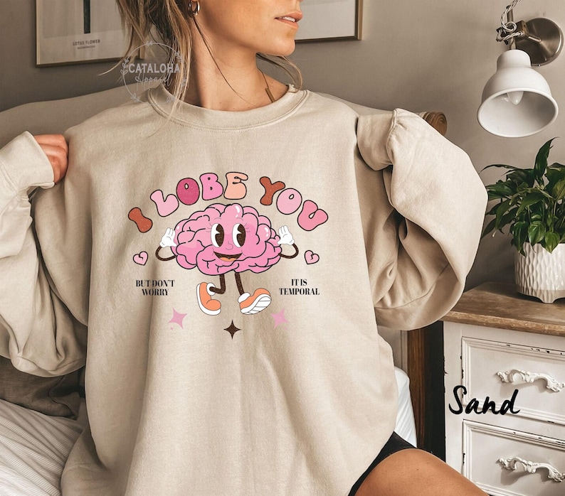 May include: A beige sweatshirt with a pink brain graphic and the text "I lobe you but don't worry it is temporal".