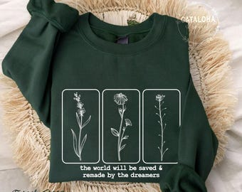 May include: Forest green sweatshirt with a white graphic of three flowers and the text "the world will be saved & remade by the dreamers".