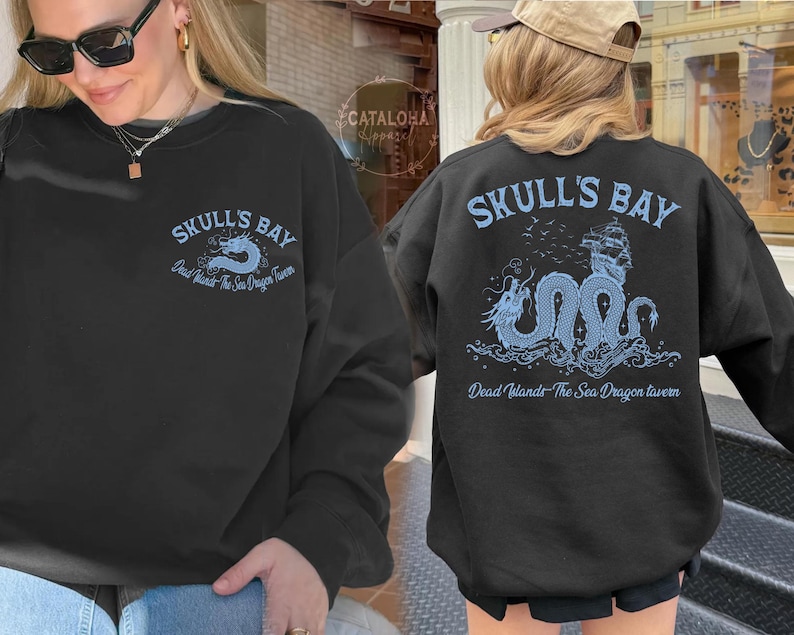 May include: Black sweatshirt with "SKULL'S BAY" text and a blue dragon graphic. The text "Dead Islands The Sea Dragon Tavern" is also printed on the sweatshirt. The design is on the front and back of the sweatshirt.