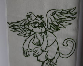Framed embroidered winged monkey.