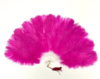 May include: A pink ostrich feather fan with a white handle and a red tassel.