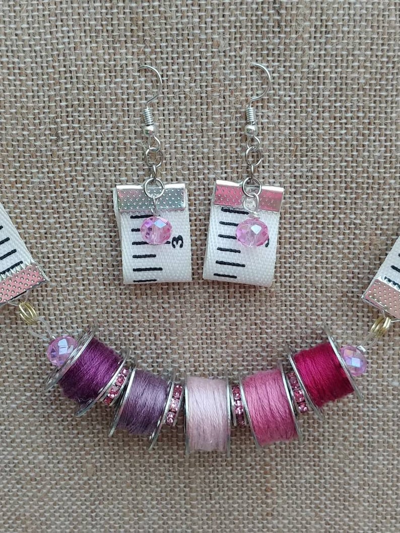 Necklace and earring set with bobbins, beads and tape measures.