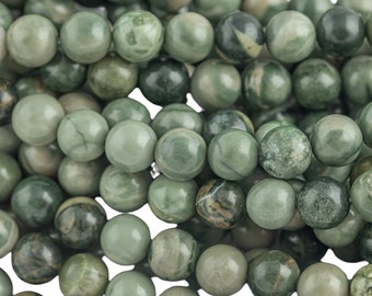 May include: A strand of green and brown jasper beads. The beads are round and have a smooth, polished finish.