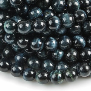 May include: A strand of dark blue tiger's eye beads. The beads are round and smooth, and they have a subtle shimmer.