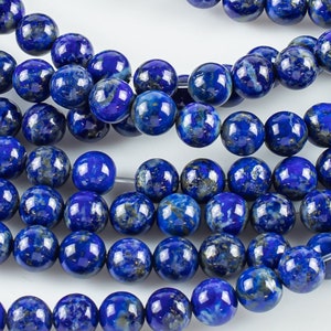 May include: A strand of deep blue lapis lazuli beads. The beads are round and have a smooth, polished finish. Lapis lazuli is a semi-precious gemstone known for its rich blue colour and flecks of gold pyrite.