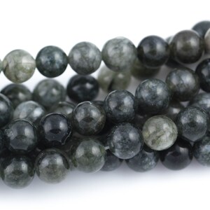 May include: A strand of dark green and white agate beads. The beads are round and have a smooth, polished finish.