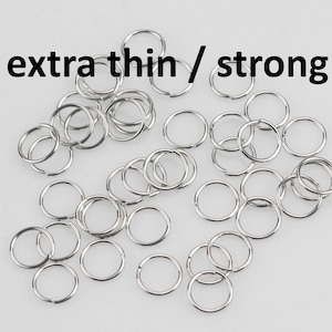 May include: A pile of silver jump rings, labeled "extra thin / strong". These rings are small and delicate, perfect for jewelry making.