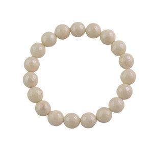 Könnte beinhalten: Ein weißes Perlenarmband mit runder Form. Die Perlen sind glatt und haben einen leichten Glanz.