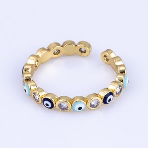 May include: Gold adjustable ring with a band of blue and white evil eye charms.