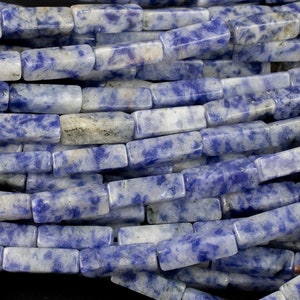 May include: A strand of blue and white rectangular gemstone beads. The beads are made of a light blue stone with white streaks and spots.