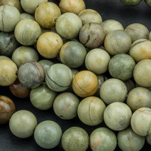 Op de afbeelding: Een streng ronde, groene, bruine en beige edelsteen kralen. De kralen zijn glad en gepolijst, met een natuurlijk, gemarmerd patroon.