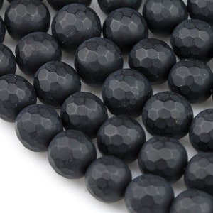 May include: A strand of black faceted agate beads. The beads are round and have a matte finish.