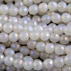 Peut inclure: Un brin de perles de verre facettées blanches irisées. Les perles sont rondes et ont une finition lisse et polie.