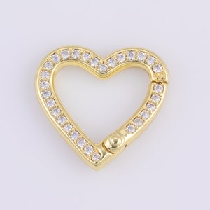 May include: Gold heart-shaped clasp with clear rhinestones around the edge.