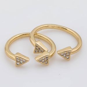 May include: Two gold rings with triangle-shaped accents set with clear cubic zirconia stones.