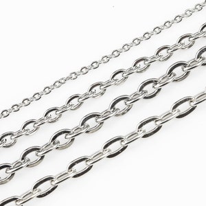 May include: Four silver chains of different sizes and thicknesses, laid out on a white background.