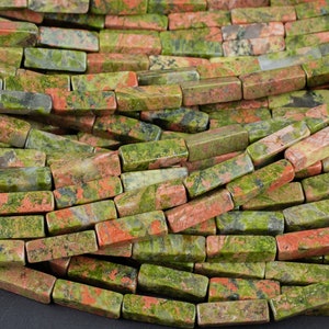 May include: A strand of green, red, and brown gemstone beads. The beads are rectangular and have a polished finish.