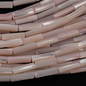 May include: A strand of pink and white shell beads, each bead is a rectangular tube shape.