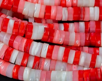 Puede incluir: Una hebra de cuentas de concha roja, rosa y blanca. Las cuentas son redondas y tienen una forma ligeramente irregular. Están enhebradas en un hilo transparente.