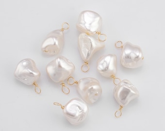 May include: A collection of ten white baroque pearls with gold jump rings. The pearls are irregular in shape and have a natural, organic look.