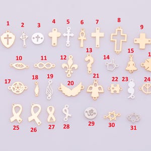 Op de afbeelding: Een verzameling goud- en zilverkleurige bedels in verschillende vormen, waaronder kruisen, engelen, vleugels en symbolen zoals een vredesteken en een Davidster. Deze bedels zijn ideaal voor het maken van sieraden.