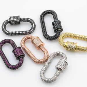 May include: Five different coloured metal lobster clasps with clear and coloured rhinestones. The clasps are in black, gold, silver, rose gold, and purple.