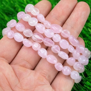 May include: Four strands of pink rose quartz gemstone beads, each strand is made of oval-shaped beads, the beads are strung on elastic.