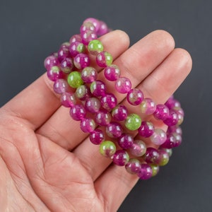 Peut inclure: Plusieurs bracelets de perles aux couleurs vives. Les perles rondes, magenta et vert citron, sont enfilées pour former des bracelets souples. Un accessoire coloré et élégant pour toutes les occasions.