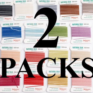 Pode incluir: Uma coleção de carretéis de fio de seda natural, rotulados como "NATURAL SILK 0.8 mm". A imagem mostra 2 pacotes de fio, com a palavra "PACKS" em letras pretas grandes. O fio é para enfiar contas.