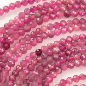 Peut inclure: Un brin de perles de pierres précieuses roses, facettées et rondes, avec une finition lisse et polie. Les perles sont enfilées sur un fil transparent et disposées en cercle.