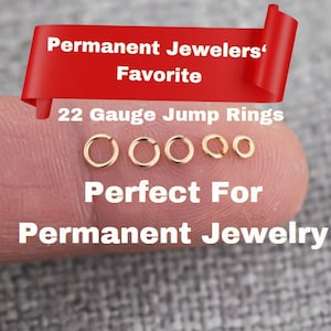May include: Five gold jump rings of different sizes on a finger. The rings are 22 gauge and are labeled "Permanent Jewelers' Favorite" and "Perfect For Permanent Jewelry".
