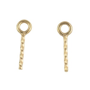 Puede incluir: Dos anillos de salto de metal dorado con un diseño de alambre retorcido. Los anillos de salto tienen un pequeño bucle en la parte superior y un alambre recto que se extiende desde la parte inferior.