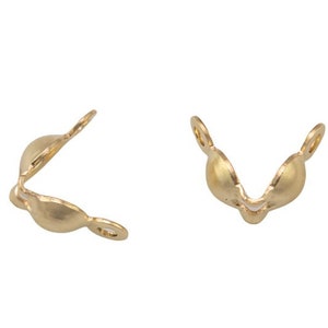 Könnte beinhalten: Zwei goldfarbene Metallverschlüsse zum Schmuckbasteln. Jeder Verschluss hat eine V-Form mit einer abgerundeten Öffnung.