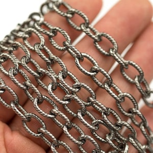 May include: A silver chain with a twisted rope design. The chain is made of metal links that are oval in shape.
