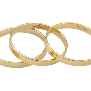 May include: Three gold-coloured rings, each with a slightly different width, are stacked on top of each other. The top ring has the inscription "1/20 14K:" on the inside.