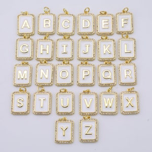 Peut inclure: Un ensemble de 26 breloques en forme de lettres de l'alphabet dorées avec émail blanc et strass transparents. Chaque breloque présente une seule lettre de l'alphabet.
