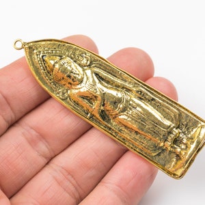 Peut inclure: Pendentif en or représentant un Bouddha debout en relief détaillé. Le pendentif a une boucle en haut pour attacher une chaîne.