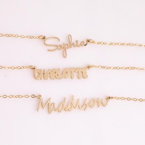 May include: Three gold necklaces with the names "Sophia", "Charlotte", and "Madison" written in cursive.