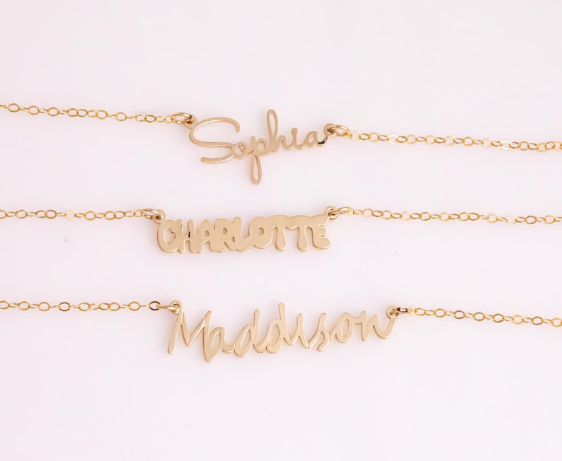 May include: Three gold necklaces with the names "Sophia", "Charlotte", and "Madison" written in cursive.