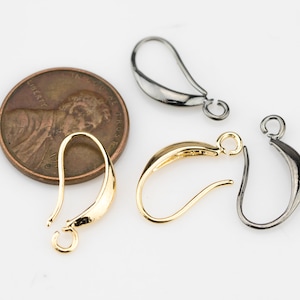 May include: Three earring hooks in gold, silver, and black metal. The hooks are about the size of a US penny.